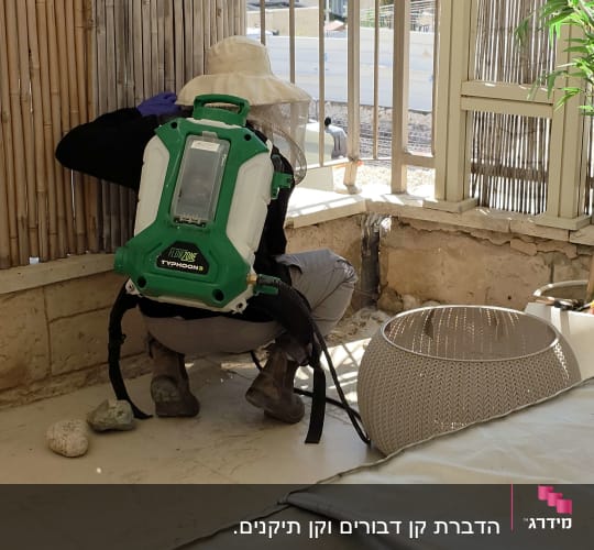 אדם עם ציוד הדברה במרפסת